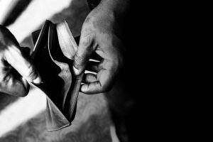 Hands holding an empty wallet, representing financial struggle, budgeting challenges, or the importance of saving money.