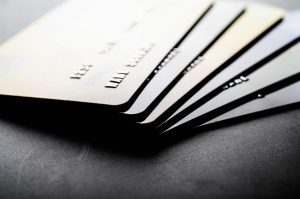 Close-up of several stacked credit cards on a dark background, highlighting concepts of credit, debt, or financial responsibility.